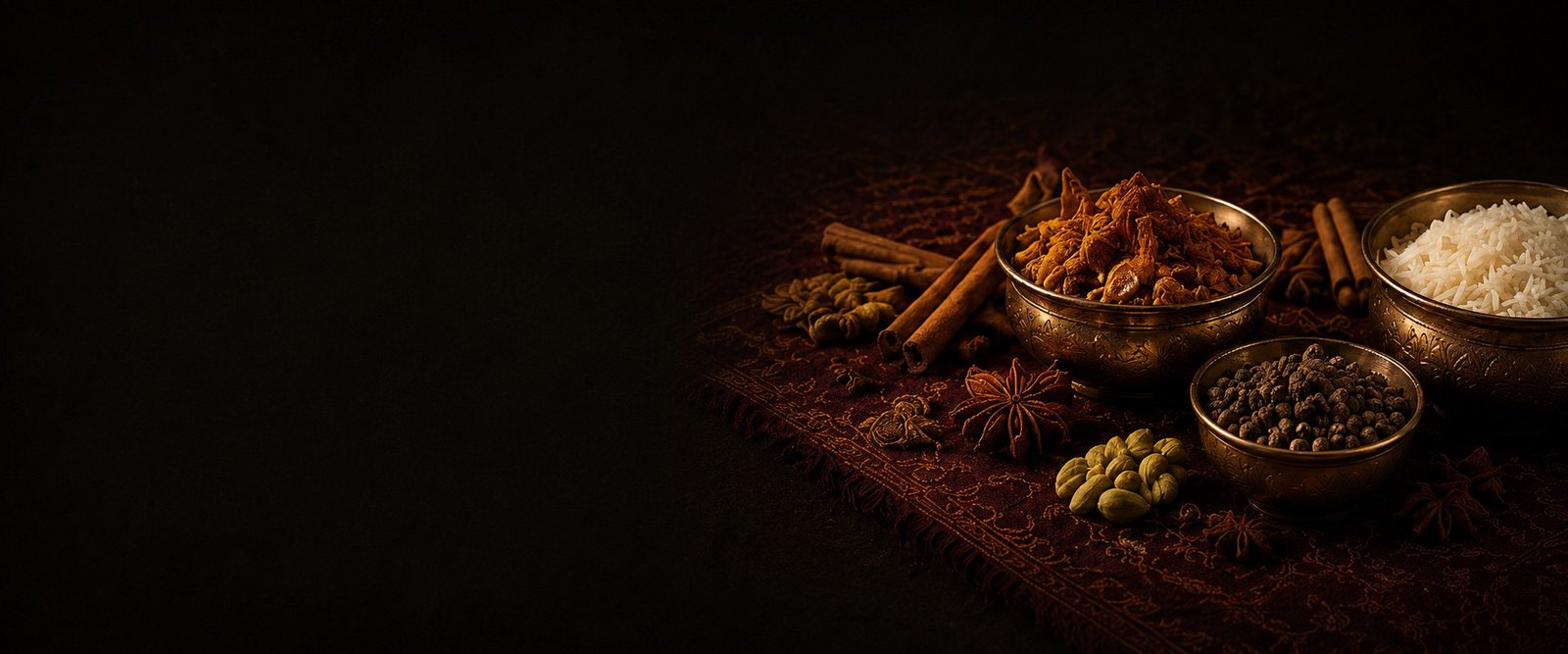 Bowls of aromatic whole spices and basmati rice on an embroidered cloth